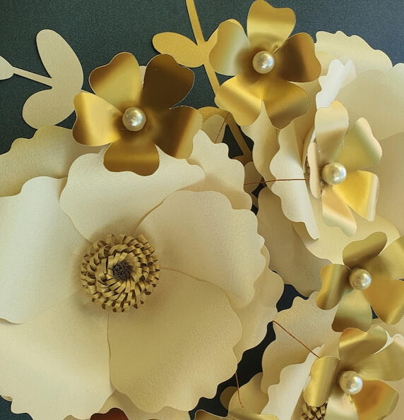 This handcrafted floral arrangement features five large cream paper flowers with golden leaves and pearl centers, adding an air of sophistication to any home or event space.